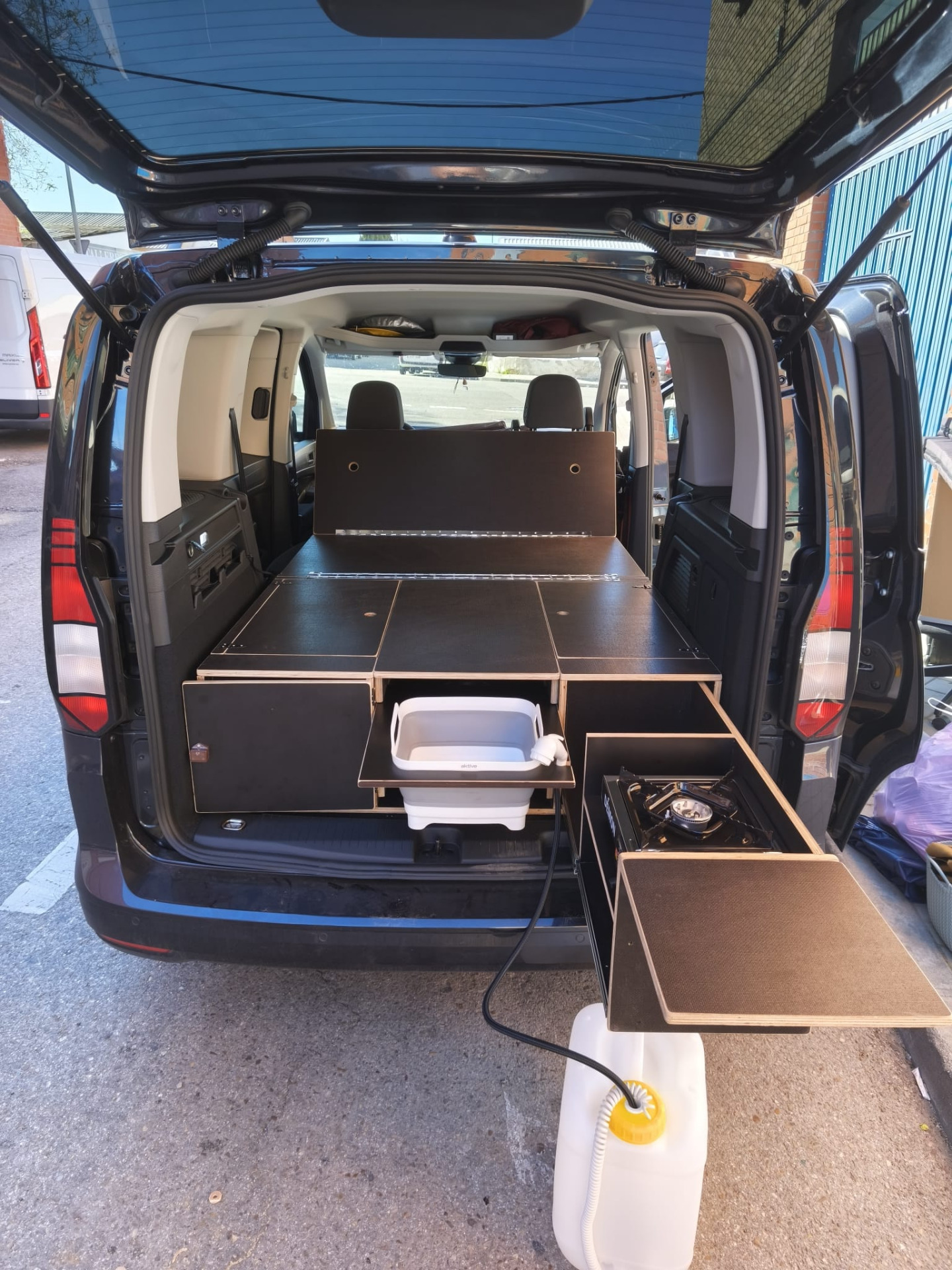 Ford Tourneo Grand Connect aménagé avec tiroir cuisine Campingaz et coffre latéral à double accès