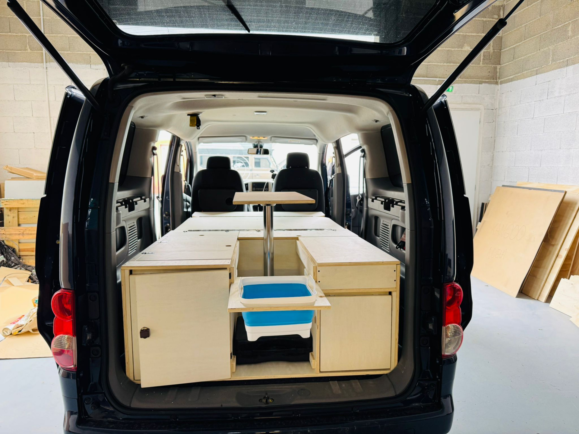 Removable Nissan Evalia camper conversion with multi-height table, dual-access storage and modular furniture