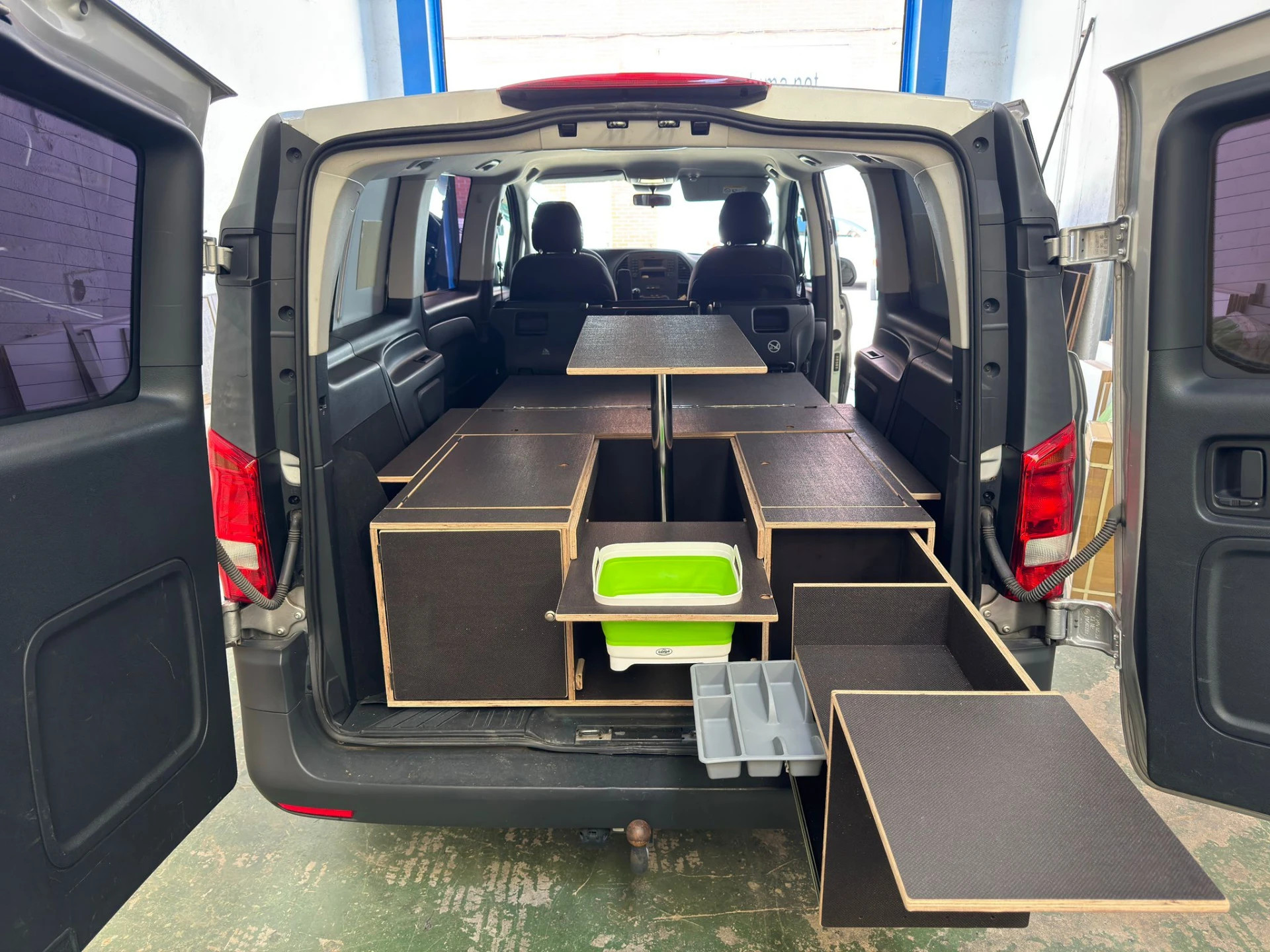 Multi-height table and pull-out Campingaz kitchen inside a Mercedes V-Class camper conversion